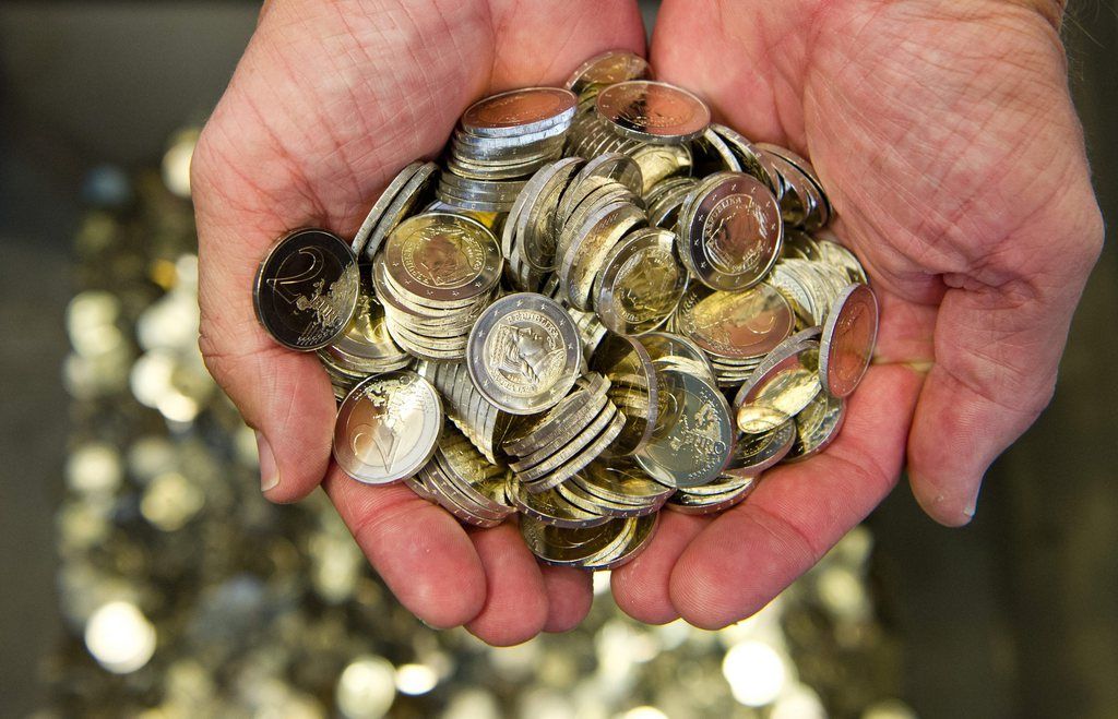 A man holds new Latvian two-euro coins in his hands in the state mint in Stuttgart, Germany, 31 July 2013. The Latvian currency, the lat, will be converted into euros at a rate of 0.7028 lats per euro, as Latvia joins the eurozone 01 January 2014.  EPA/DANIEL BOCKWOLDT