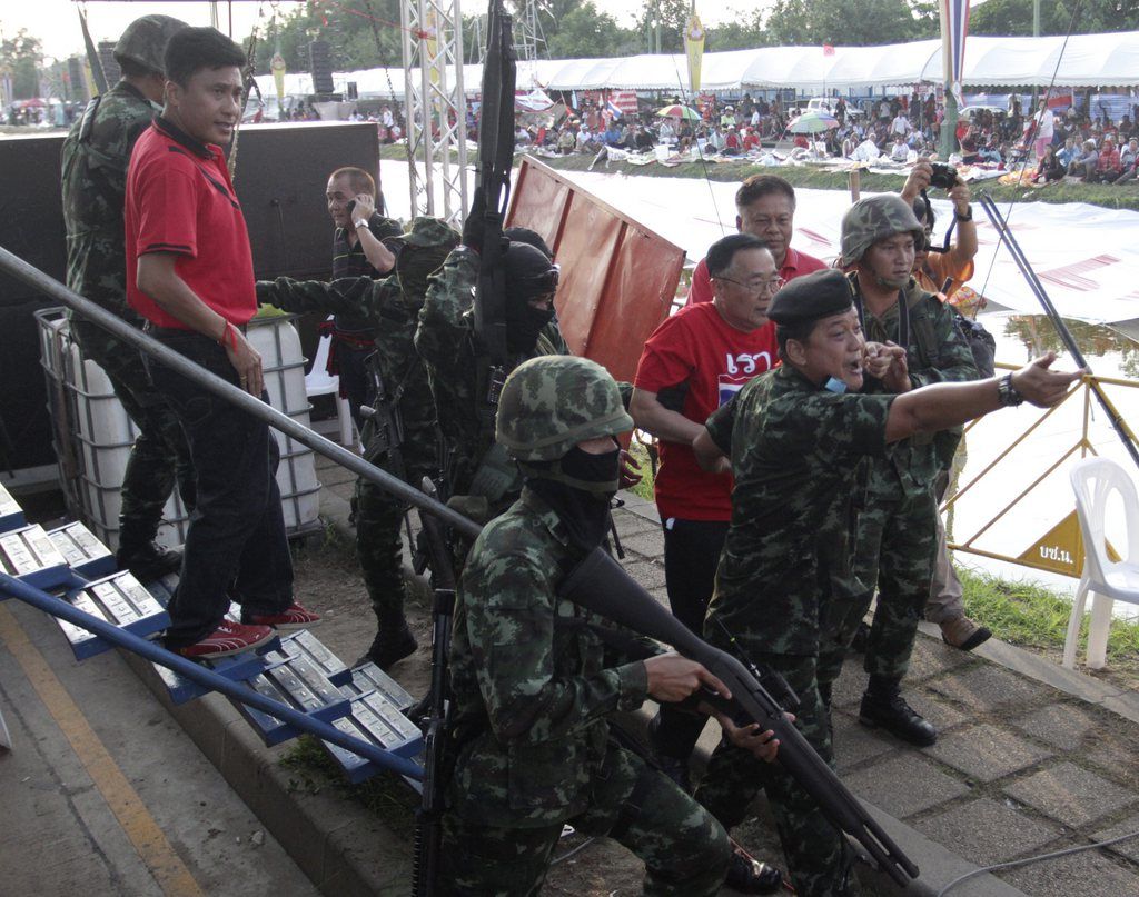 epa04219346 Thai soldiers arrest core leaders of the pro-government Red Shirt group, Weng Tojirakarn (R) and an unidentified comrade after the army declared coup at the rally site on the outskirts of Bangkok, Thailand, 22 May 2014 Thai soldiers began clearing the site of pro-government protesters in western Bangkok, hours after the commander-in-chief declared a coup. The Thai Army announced a coup after efforts to reconcile rival political factions failed. The talks, which started a day earlier, were the first since anti-government protests broke out in early November.  EPA/STR