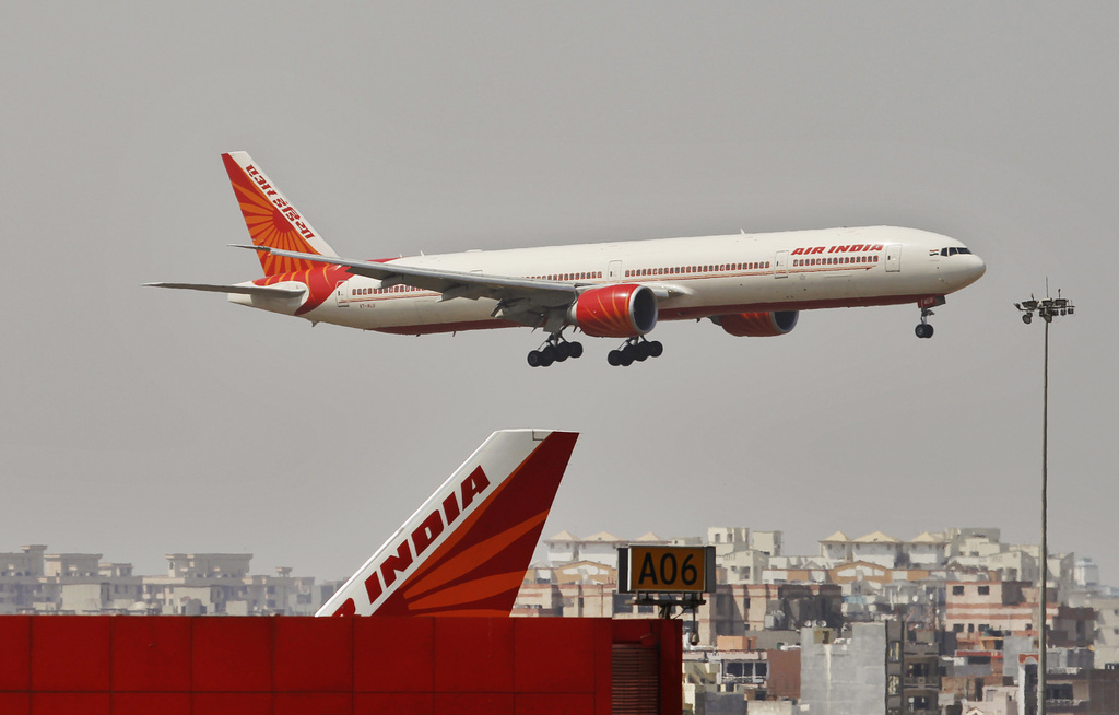 An Air India plane flies in New Delhi, India, Thursday, April 12, 2012. The Indian government approved a debt restructuring plan to help save Air India. The once proud national airline is mired in debt as it struggles with the legacy of a poorly executed 2007 merger and a swollen work force. (AP Photo/Tsering Topgyal)