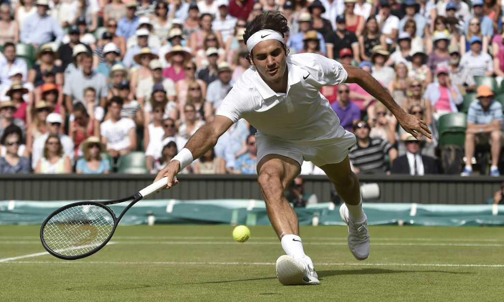 Roger Federer of Switzerland reaches for the ball to play a return to Stan Wawrinka of Switzerland during their men's singles quarterfinal match at the All England Lawn Tennis Championships in Wimbledon, London, Wednesday July 2, 2014. (AP Photo/Toby Melville, Pool)