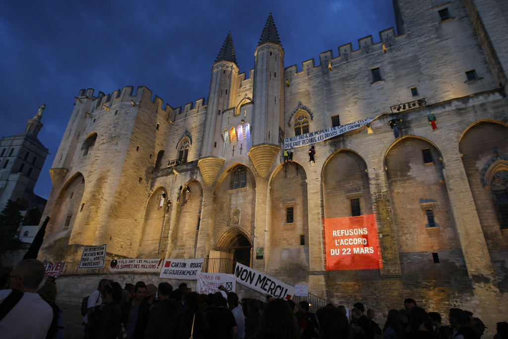 Protesting banners are displayed on the wall of the Palais des Papes in Avignon, France, Friday, July 4, 2014. Organizers of one of Europe?s premier theater festivals are canceling some shows amid a protest movement by cultural workers over changes to their off-season unemployment benefits. The dispute threatens to disrupt arts festivals across the country this summer. The red banner reads: "Let us refuse the agreement of March 22." (AP Photo/Claude Paris)