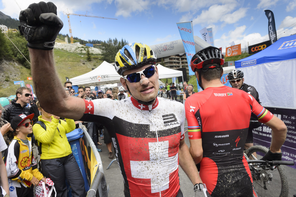 Winner Urs Huber, left, from Switzerland celebrates after crossing the finish line in front of second placed Christoph Sauser from Switzerland, right, during the 25th Swiss Mountain Bike Marathon "Grand Raid" from Verbier to Grimentz, Southwestern Switzerland, Saturday, August 23, 2014. More than 2'600 mountainbikers participated in the race from Verbier to Grimentz. (KEYSTONE/Laurent Gillieron)