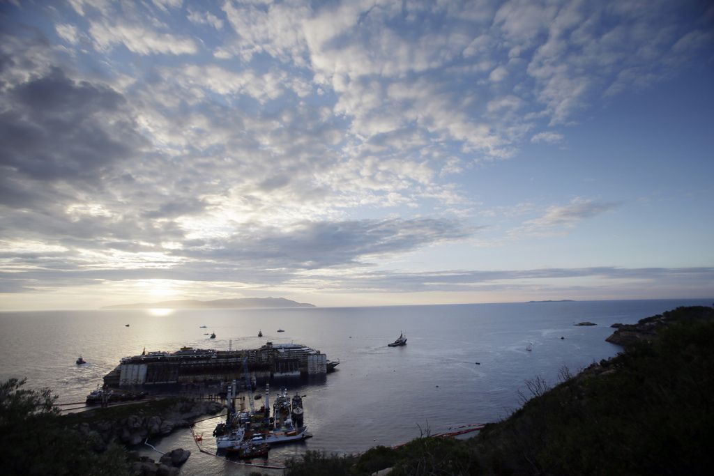 The Costa Concordia cruise ship is almost ready to be towed away from the tiny Tuscan island of Isola del Giglio, Italy, Wednesday, July 23, 2014. The wreck of the Costa Concordia is expected to be towed to the Italian port of Genoa on Wednesday, where it will be scrapped. Thirty-two people died when it slammed into the reef and started capsizing on Jan. 13, 2012. The body of one victim is still missing. (AP Photo/Gregorio Borgia)