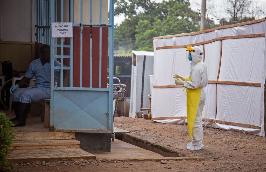 In this photo taken on Tuesday, Aug 12, 2014, a healthcare worker, right, wears protective gear against the Ebola virus before he enters the Ebola isolation ward at Kenema Government Hospital, in Kenema, the Eastern Province around 300km, (186 miles),  from the capital city of Freetown in Sierra Leone.  Over the decades, Ebola cases have been confirmed in 10 African countries, including Congo where the disease was first reported in 1976. But until this year, Ebola had never come to West Africa. (AP Photo/ Michael Duff)