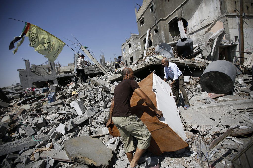 An Israeli woman looks at damage of a house hit by a rocket fired from the Gaza Strip Saturday  in the southern city of Beersheba, Israel, Saturday, July 12, 2014. Israeli airstrikes overnight targeting Hamas in Gaza hit a mosque its military says concealed the militant group's weapons, in an offensive that showed no signs of slowing down. Israel launched its campaign five days ago to stop relentless rocket fire on its citizens. While there have been no fatalities in Israel, Palestinian officials said overnight attacks raised the death toll there to over 120, with more than 920 wounded. (AP Photo/Tsafrir Abayov)