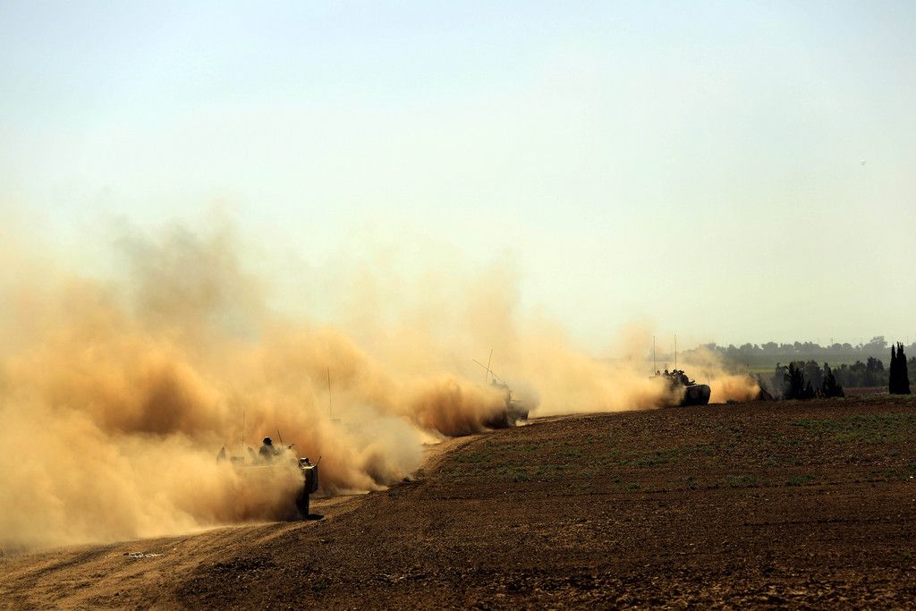 Israeli Merkava tanks drive in southern Israel as they advance towards the Israel Gaza border, Friday, Aug. 1, 2014. (AP Photo/Tsafrir Abayov)
