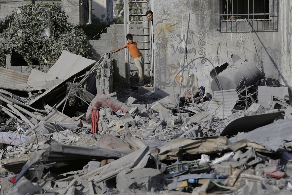 Palestinians inspect the damage, after an overnight Israeli strike, to several buildings in Gaza City, northern Gaza Strip, Saturday, Aug. 2, 2014. (AP Photo/Lefteris Pitarakis)