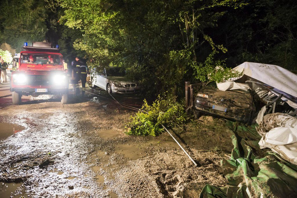 epa04339496 Rescue teams conduct a search operation near a car that was swept away by a torrent near Treviso, northern Italy, 03 August 2014. Four people died in heavy downpour the previous night.  EPA/STEFANO COVRE