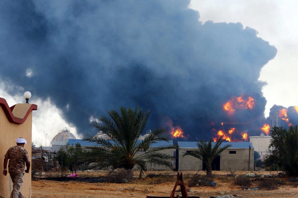 epa04339122 A huge pall of smoke rises on the hirozon after rockets fired by one of Libya's militias struck and ignited a tank in the capital's main fuel depot, in Tripoli, Libya 02 August 2014.  EPA/SABRI ELMHEDWI