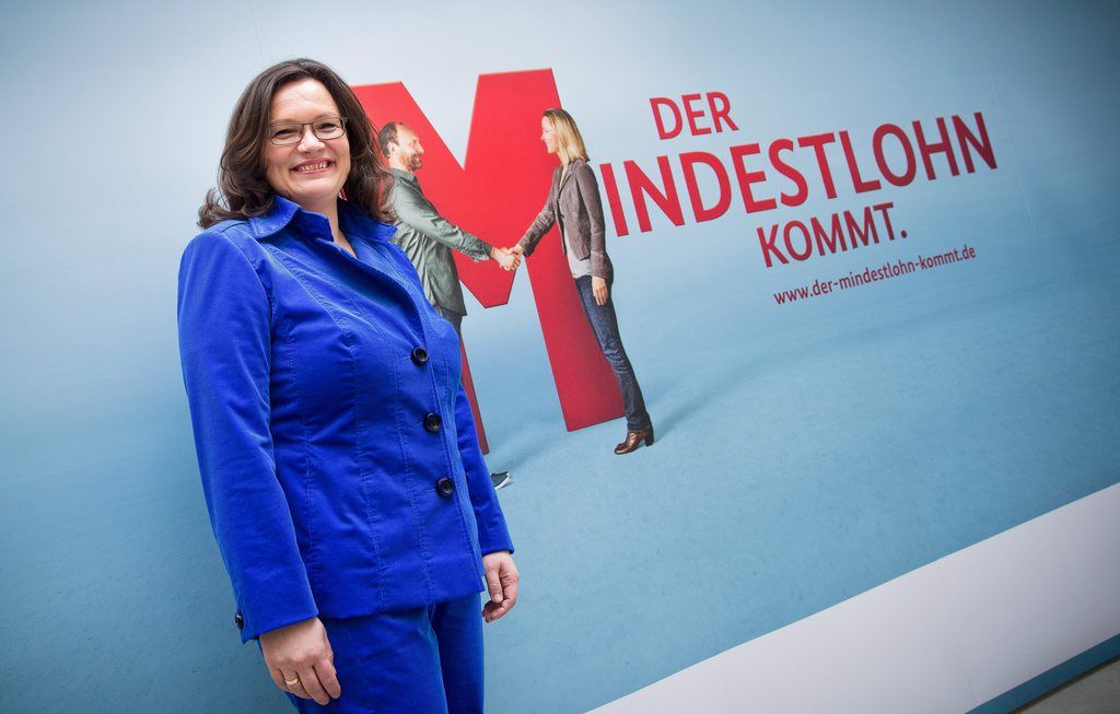 epa04150554 German Minister of Labor and Social Affairs Andrea Nahles poses in front of a placard reading 'Minimum wage is on the way' in Berlin, Germany, 02 April 2014. Nahles presented the framework conditions for the introduction of a nationwide minimum wage in Germany at a press conference in the German capital.  EPA/MICHAEL KAPPELER