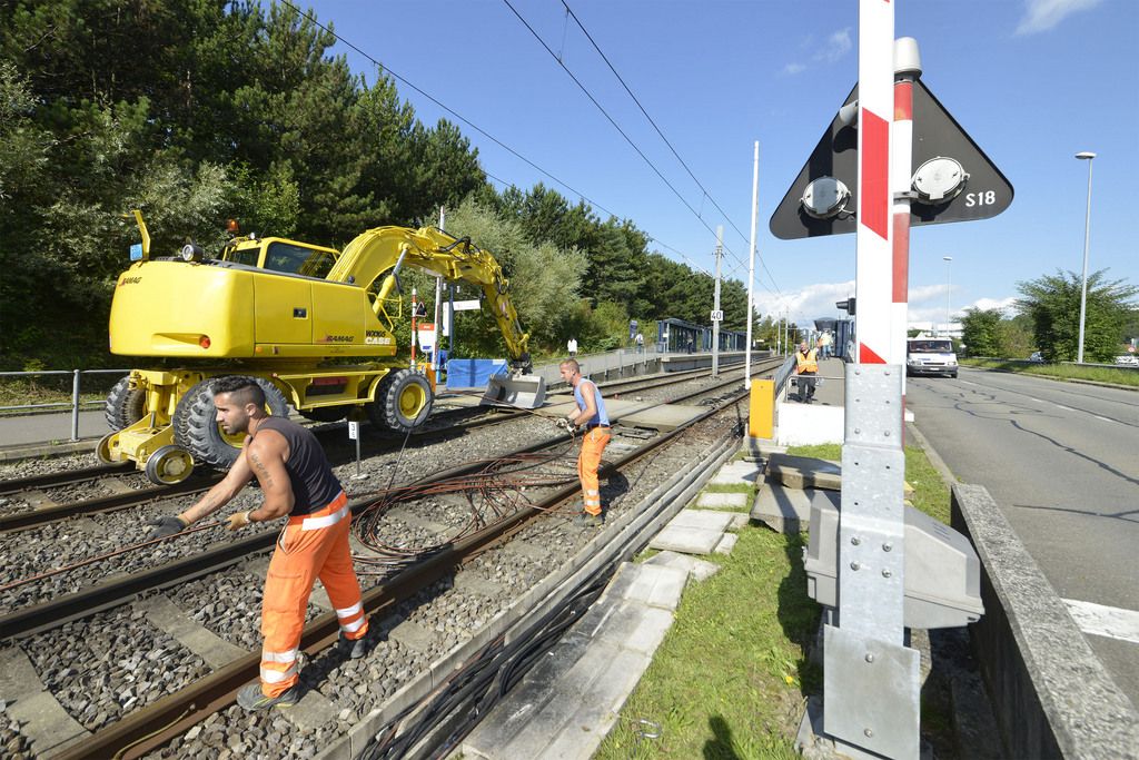 De nombreux ouvriers s'activent a reparer des degats ce jeudi 21 aout 2014 a Lausanne. Un court-circuit a eu lieu sur la ligne du metro M1 pres de l'arret de l'UNIL de Dorigny a Lausanne. Les cables de fibre optique de l'operateur Sunrise on ete abimes et le trafic du metro M1 a du etre interrompu. (KEYSTONE/Christian Brun)