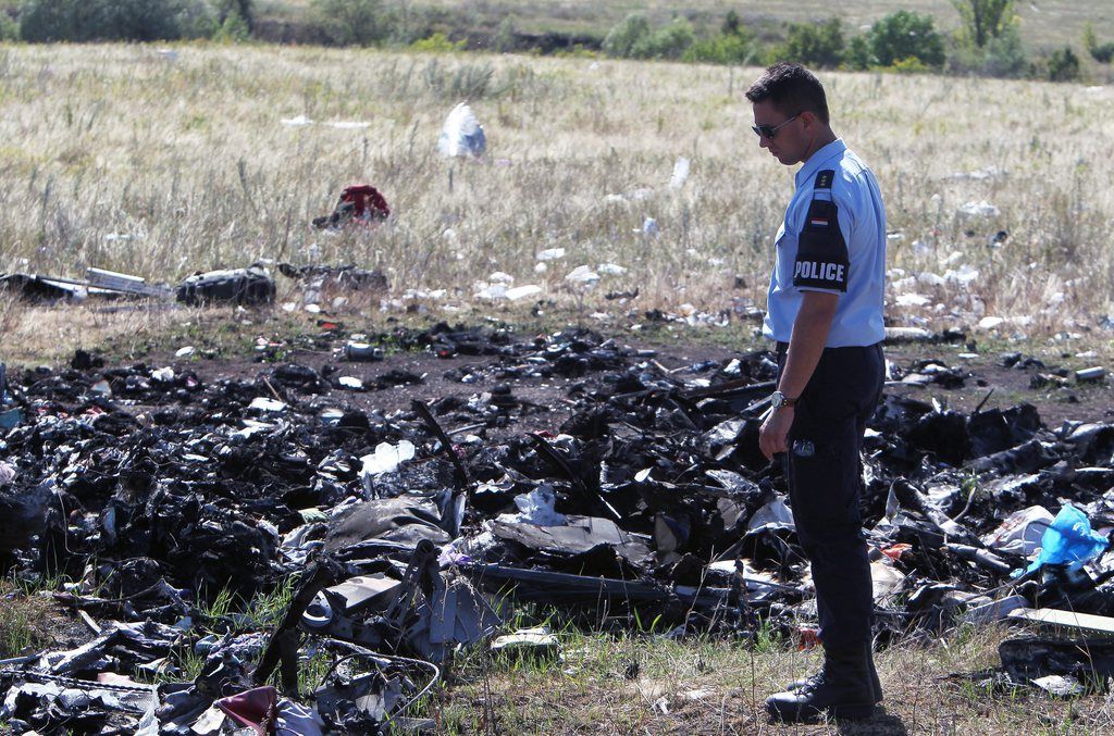 epa04337939 Australian and Dutch investigators examine the area of Malaysia Airlines Flight MH17 plane crash site, near the village of Hrabove, 100 km from  Donetsk, Ukraine, 01 August 2014. A group of international experts arrived 01 August at the site of the crash of Malaysia Airlines MH17 in eastern Ukraine after the government halted military operations against Russia-backed rebels. The Dutch government said members of the Organization for Security and Co-operation in Europe (OSCE), as well as Australian and Dutch experts, had reached the scene of the crash, where up to 80 bodies could still be laying. Most of the victims on the plane, which is suspected of having been shot down by rebels on July 17, were Dutch, Malaysian and Australian.  EPA/IGOR KOVALENKO