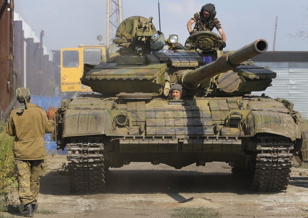 Pro-Russian rebels park a tank on their base near the town of Krasnodon, eastern Ukraine, Saturday, Aug. 16, 2014. Tanks and APC's manoeuvre on the Ukrainian side of Ukrainian-Russia border as the humanitarian convoy on the other side of the frontier is still unmoved. (AP Photo/Sergei Grits)