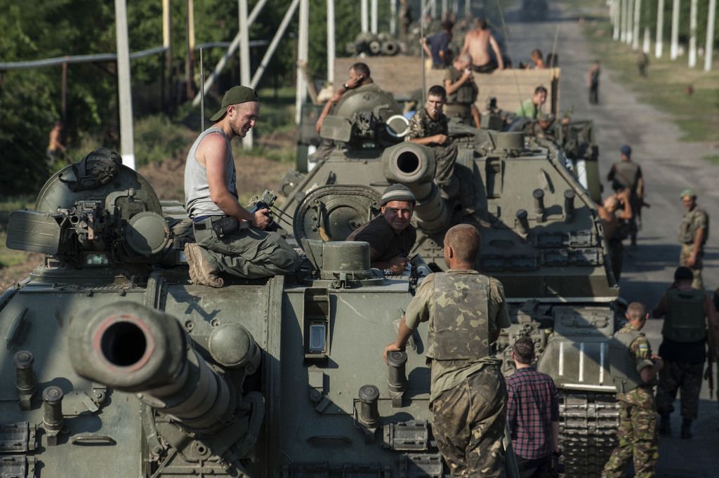 In this photo taken Thursday, Aug. 14, 2014, Ukrainian soldiers prepare their self-propelled guns as part of an army column of military vehicles to roll to a frontline near Illovaisk, Donetsk region, eastern Ukraine. Ukrainian forces have stepped up efforts to dislodge the separatists from their last strongholds in Donetsk and Luhansk and there was more heavy shelling overnight. (AP Photo/Evgeniy Maloletka)