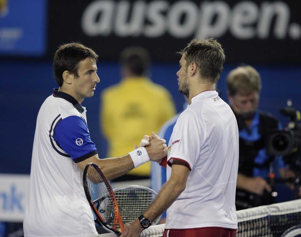 Stanislas Wawrinka of Switzerland, right, shakes hands with Tommy Robredo of Spain after Wawrinka won their fourth round match at the Australian Open tennis championship in Melbourne, Australia, Sunday, Jan. 19, 2014.(AP Photo/Rick Rycroft)