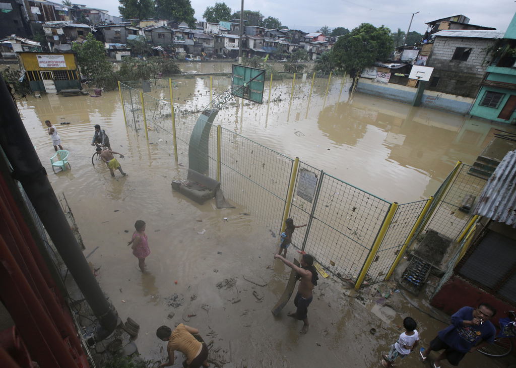Residents continue to be inundated by floodwaters Saturday, Sept. 20, 2014 at Marikina city, east of Manila, Philippines. Tropical Storm Fung-Wong that brought torrential monsoon rains which flooded much of the Philippine capital gained strength and battered the country's northernmost provinces Saturday with heavy downpours and strong winds. (AP Photo/Bullit Marquez)