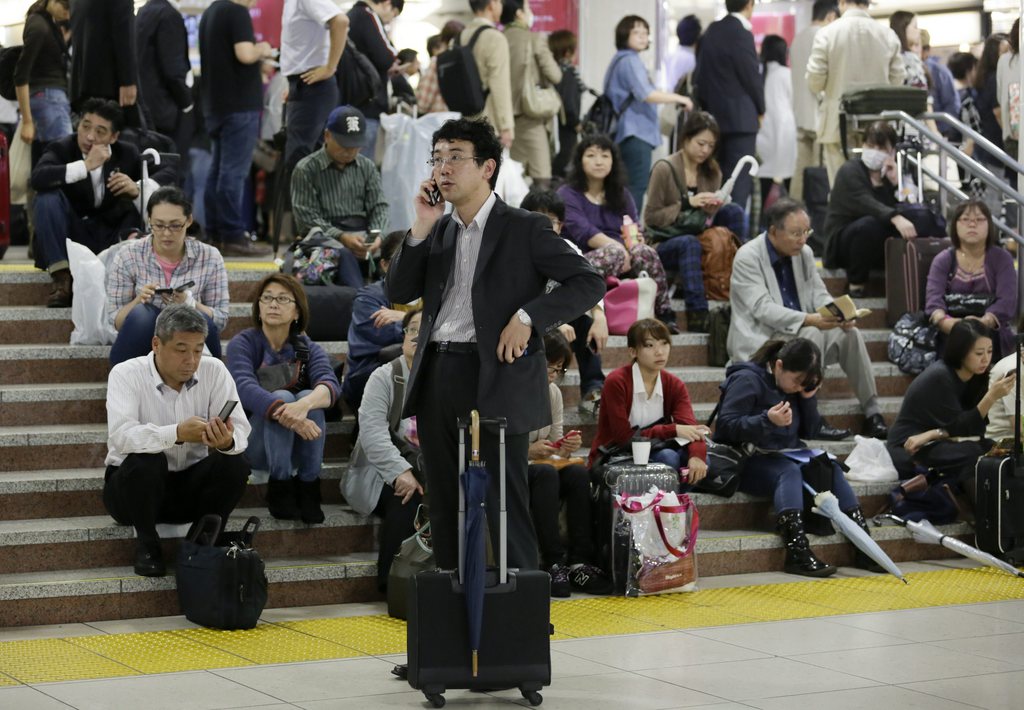 epa04434139 Passengers of JR Tokai's Shinkansen bullet train are waiting for the resumption of the service at JR Tokyo Station in Tokyo, Japan, 06 October 2014, after the bullet train suspended the service between Tokyo and Nagoya due to a powerful typhoon. Typhoon Phanfone is hitting through southwestern, western and central Japan with heavy rain and strong winds after lashing western and southern Japan, leaving two dead and three missing. Hundreds of thousands of people were advised to evacuate their homes with the Japan Meteorological Agency warning of mudslides, heavy rains, swollen rivers and strong winds in wide areas of the country.  EPA/KIMIMASA MAYAMA