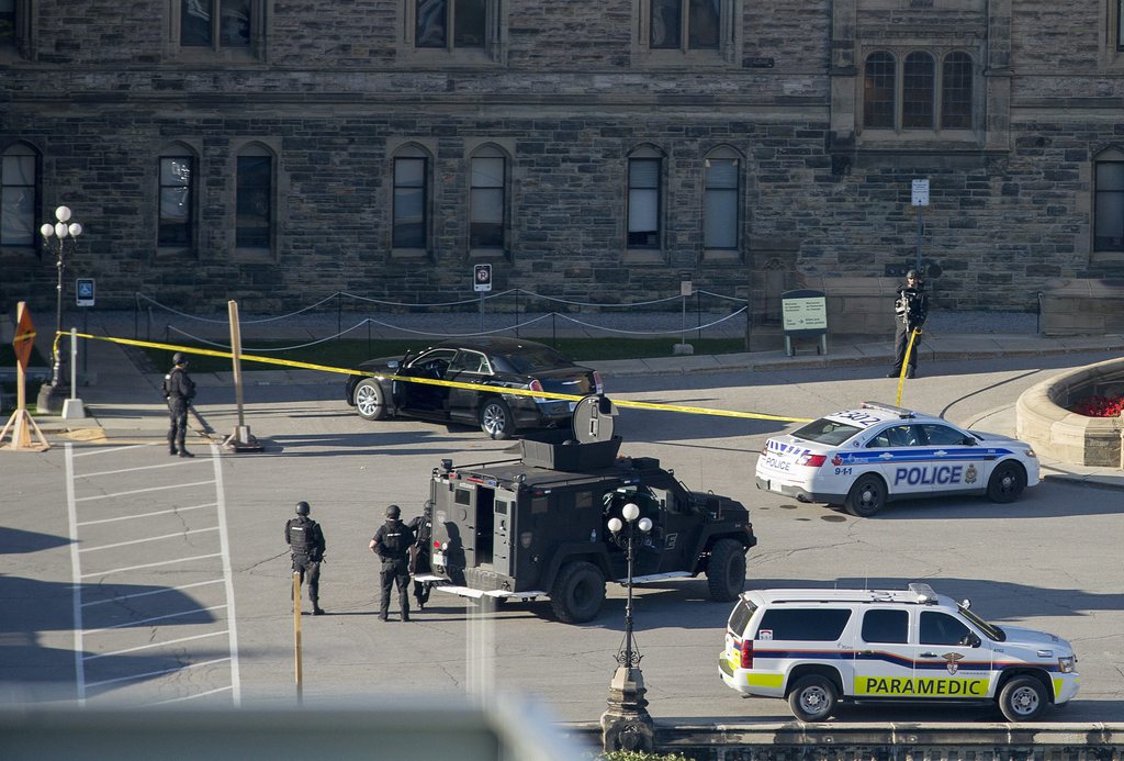 Police teams set up police tape outside Centre Block on Parliament Hill in Ottawa, Ontario, on on Wednesday, Oct. 22, 2014. A gunman opened fire at the National War Memorial, killing a soldier, then moved to nearby Parliament Hill and was shot and killed by Parliament's sergeant-at-arms. (AP Photo/The Canadian Press, Justin Tang)