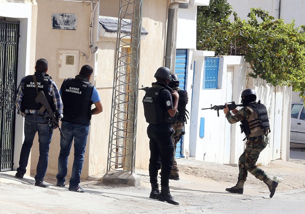 epa04459358 Tunisian soldiers stand guard at the area where police forces exchanged gunfire with alleged militants who had taken refuge in a house in the town of Oued Ellil, on the outskirts of the capital Tunis, Tunisia, 23 October  2014. According to Mohamed Ali Aroui, spokesman for the Interior Ministry, security forces surrounded a house containing a suspected terror cell believed to have been planning an attack during the upcoming parliamentary elections 26 October, and reports state as the opeation continued at least one Tunisian policeman was killed and several others wounded in an ensuing fire fight between Tunisian security forces and those inside the building.  EPA/MOHAMED MESSARA