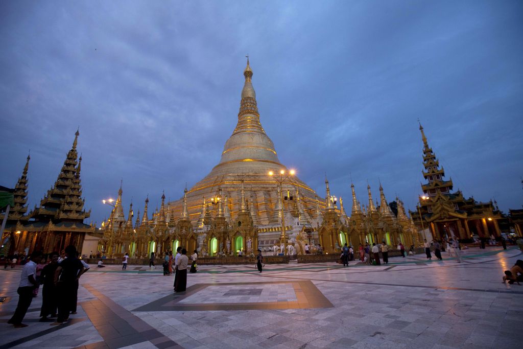 In this Aug. 13, 2014 photo, Buddhist devotees visit Myanmar famous Shwedagon Pagoda while it is illuminated in Yangon, Myanmar. Situated on a hilltop in the old capital of Yangon, the 99-meter (326-foot) high Shwedagon draws hundreds of visitors every day. (AP Photo/Khin Maung Win)