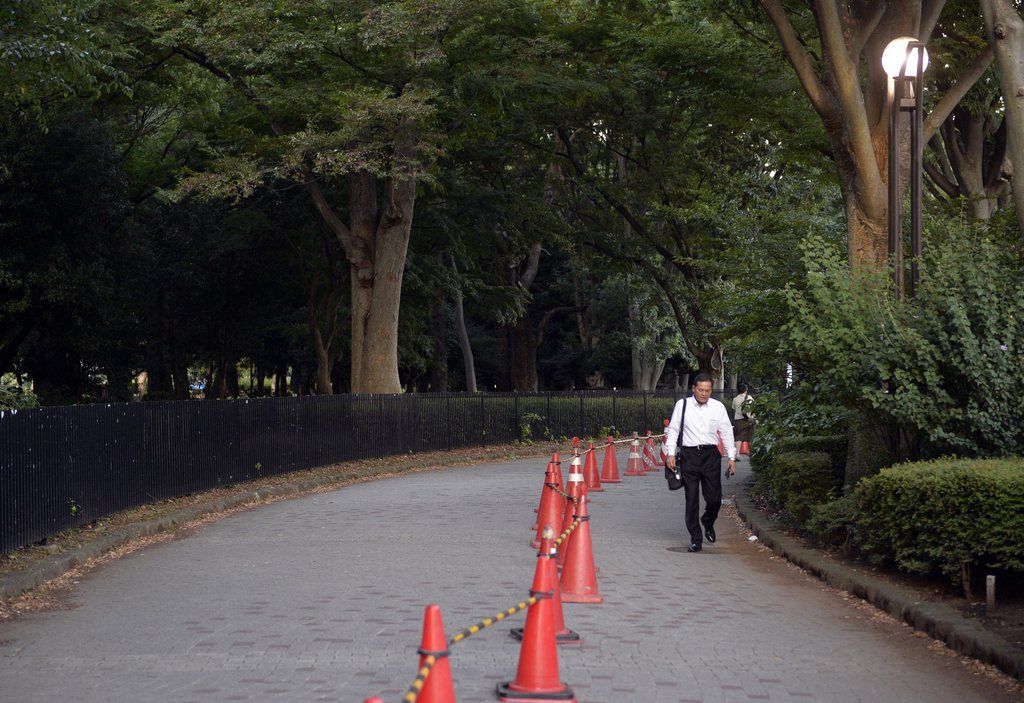 epa04385374 A man walks next to Yoyogi Park, which has been closed to the public, in Tokyo, Japan, 05 September 2014. Large areas of a public park in central Tokyo were closed to visitors on 04 September after researchers there discovered mosquitoes carrying the dengue fever virus, confirming the park as a source of the recent outbreak. It was reported to be the first major closure of the popular park, one of Tokyo's biggest, since it was opened in 1967. The number of people infected with dengue fever in Japan is exceeding 60 according to latest reports.  EPA/FRANCK ROBICHON