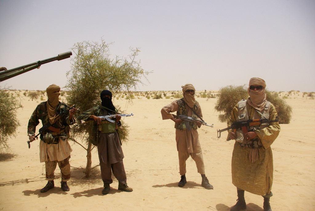 FILE - In this April 24, 2012 file photo, fighters from Islamist group Ansar Dine stand guard during a hostage handover in the desert outside Timbuktu, Mali. In recent months, al-Qaida and its allies have taken advantage of political instability within Mali to push out of their hiding place and into the towns, taking over an enormous territory which they are using to stock arms, train forces and prepare for global jihad. And as 2012 draws to a close and the world hesitates, delaying a military intervention, the extremists who seized control of the area earlier this year are preparing for a war they boast will be worse than the decade-old struggle in Afghanistan. (AP Photo/File)