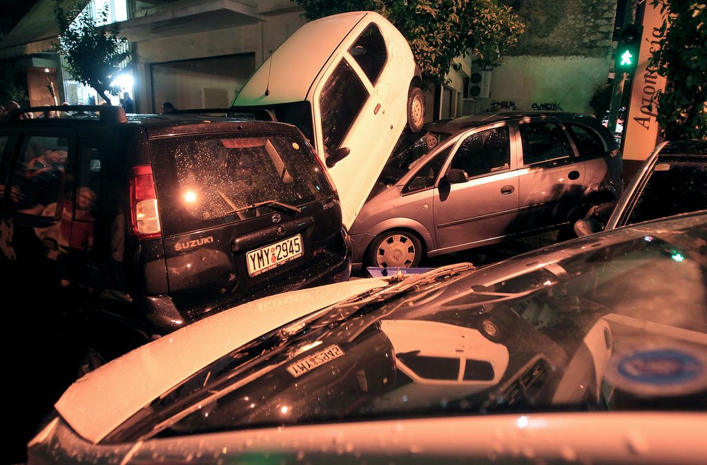 epa04462260 Piled up vehicles are seen in a street in Athens, Greece, on 24 October 2014. Heavy rain caused flash flooding in many parts of Athens 24 October, sweeping cars through streets and leaving shops and homes knee-deep in muddy water.  EPA/SIMELA PANTZARTZI