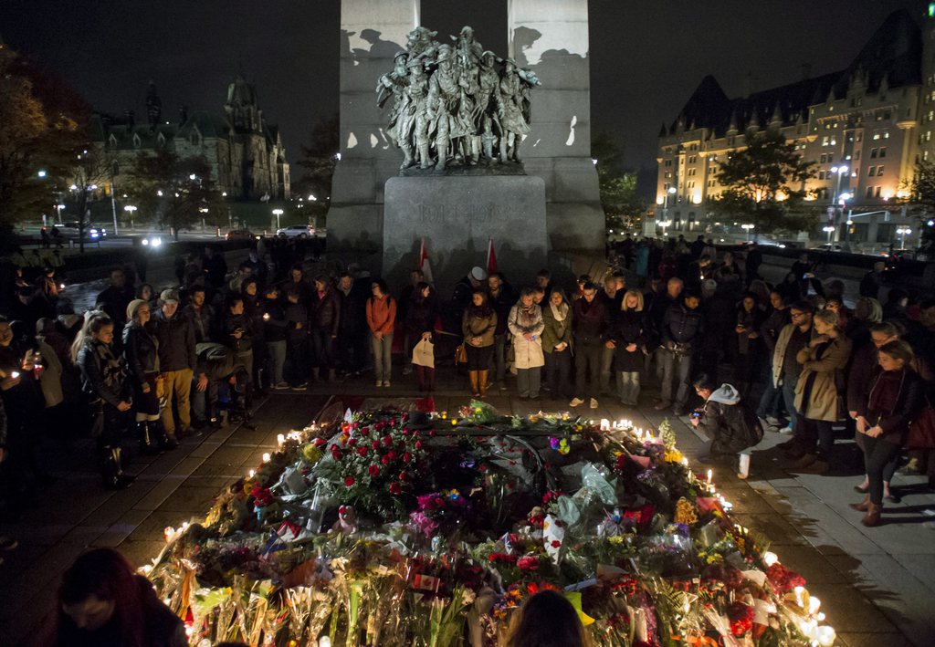 The Tomb of the Unknown Soldier at the National War Memorial is surrounded by people during a candlelight vigil in Ottawa on Saturday, Oct. 25, 2014. People gathered in tribute of Cpl. Nathan Cirillo, 24, a reservist from Hamilton, Ontario, who was killed on Wednesday. (AP Photo/The Canadian Press, Justin Tang)