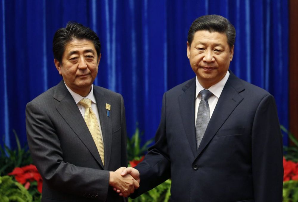 Shinzo Abe (à gauche) et Xi Jinping ont échangé une brève pogné de main.