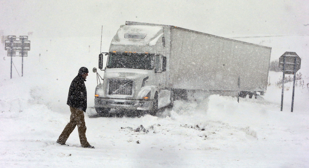 Omer Odovsc walks in front of his tractor trailer that got stuck on the 219 off ramp leading to Rt. 391 in Boston, N.Y., Tuesday, Nov. 18, 2014. Parts of New York measured the season's first big snowfall in feet, rather than inches, on Tuesday as 3 feet of lake-effect snow blanketed the Buffalo area and forced the closure of a 132-mile stretch of the state Thruway. (AP Photo/The Buffalo News, Harry Scull Jr.)  TV OUT; MAGS OUT; MANDATORY CREDIT; BATAVIA DAILY NEWS OUT; DUNKIRK OBSERVER OUT; JAMESTOWN POST-JOURNAL OUT; LOCKPORT UNION-SUN JOURNAL OUT; NIAGARA GAZETTE OUT; OLEAN TIMES-HERALD OUT; SALAMANCA PRESS OUT; TONAWANDA NEWS OUT