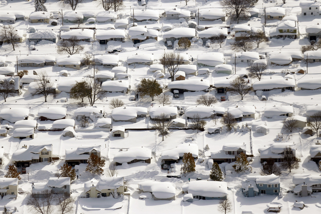 Homes are covered in snow in West Seneca, N.Y.,Wednesday, Nov. 19, 2014. The Buffalo area found itself buried under as much as 5? feet of snow Wednesday, with another lake-effect storm expected to bring 2 to 3 more feet by late Thursday.  (AP Photo/The Buffalo News, Derek Gee)  TV OUT; MAGS OUT; MANDATORY CREDIT; BATAVIA DAILY NEWS OUT; DUNKIRK OBSERVER OUT; JAMESTOWN POST-JOURNAL OUT; LOCKPORT UNION-SUN JOURNAL OUT; NIAGARA GAZETTE OUT; OLEAN TIMES-HERALD OUT; SALAMANCA PRESS OUT; TONAWANDA NEWS OUT