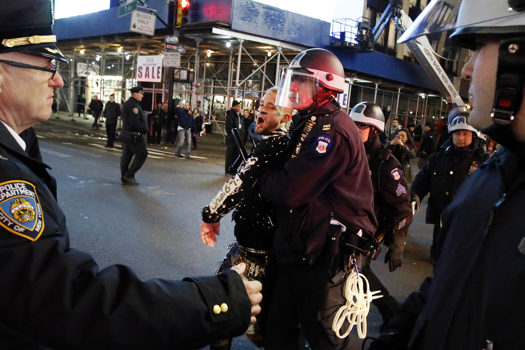 Police make arrests as protesters rallying against a grand jury's decision not to indict the police officer involved in the death of Eric Garner march near Times Square, Thursday, Dec. 4, 2014, in New York. (AP Photo/Jason DeCrow)