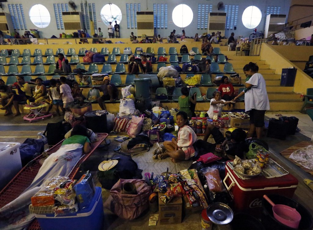 epa04517098 Filipino residents rest inside a gymnasium turned into a temporary evacuation center in Tacloban city, Leyte island, Philippines, 06 December 2014. Typhoon Hagupit is speeding up and expected to make landfall in the eastern Philippines later 06 December, a senior weather official said.  EPA/FRANCIS R. MALASIG