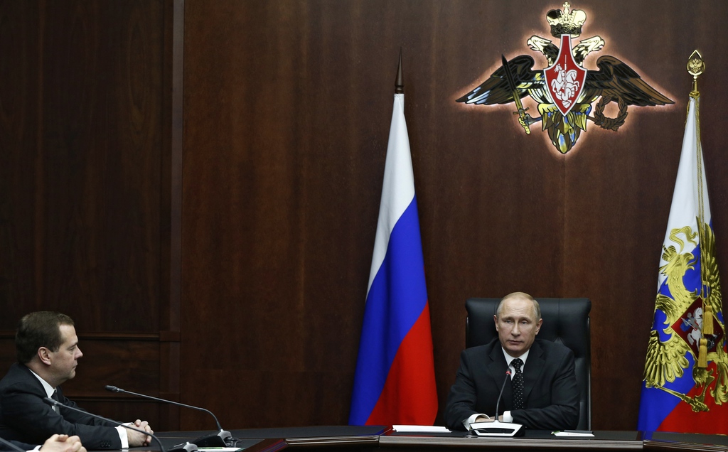 Russian President Vladimir Putin, center, heads a meeting with senior military officials as Russian Prime Minister Dmitry Medvedev, left, listens to him at the Defense Ministry's control room in Moscow, Russia on Friday, Dec. 19, 2014.Putin says Russia will continue its ambitious military modernization program with a particular emphasis on nuclear strategic forces. Speaking at Friday's meeting with top military brass, Putin said the nation's nuclear forces are a "major factor in maintaining global balance," adding that "they effectively include a possibility of large-scale aggression against Russia." (AP Photo/RIA Novosti, Alexei Druzhinin, Presidential Press Service)