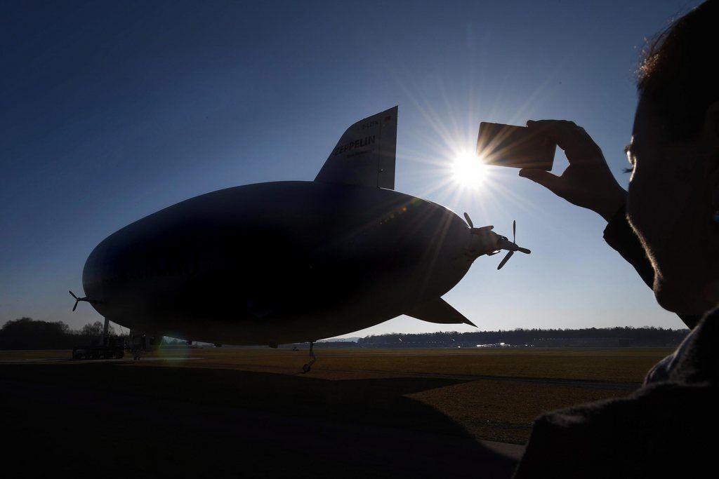 epa04129386 Andrea Fischer, spokeswoman of the German  Zeppelin airship company, photographs a Zeppelin NT at the beginning of its new season in Friedrichshafen, Germany, 17 March 2014. The Zeppelin company expects a total of more than 1,000 flights in the 2014 season.  EPA/FELIX KAESTLE