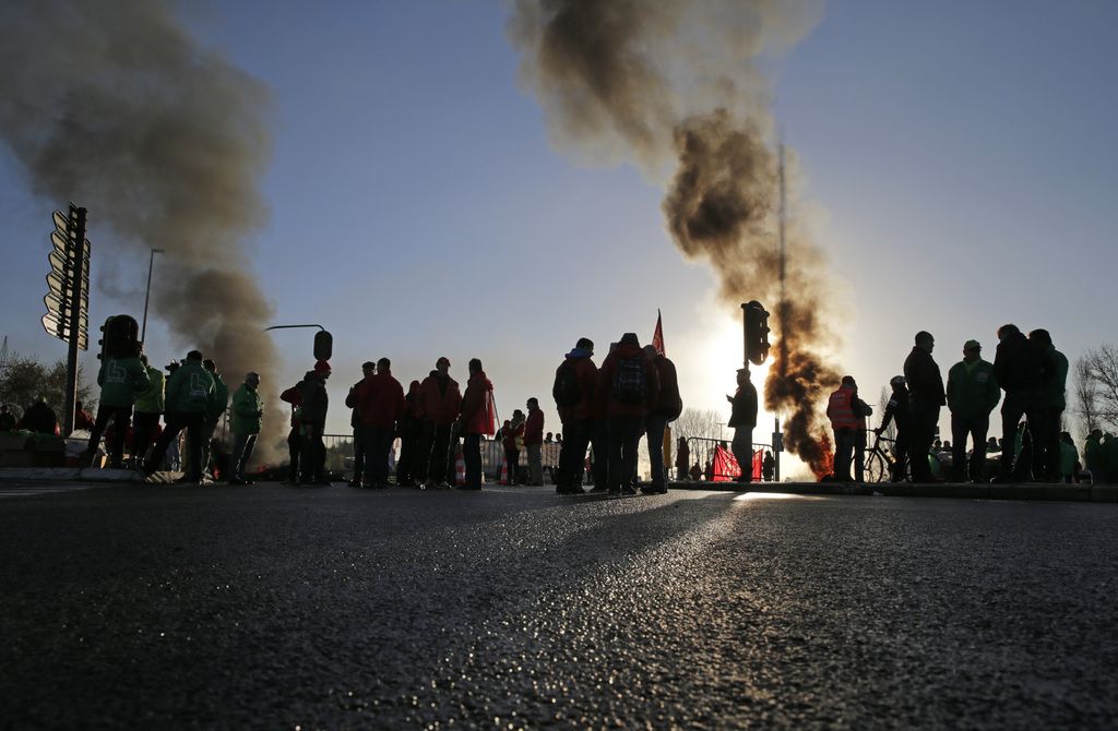Workers of all major trade unions block an intersection at the port of Antwerp, Belgium, Monday, Nov. 24, 2014.  Trade unions have opened a month of intermittent strike action by paralyzing the port of Antwerp and slowing train traffic through much of Belgium. (AP Photo/Yves Logghe)