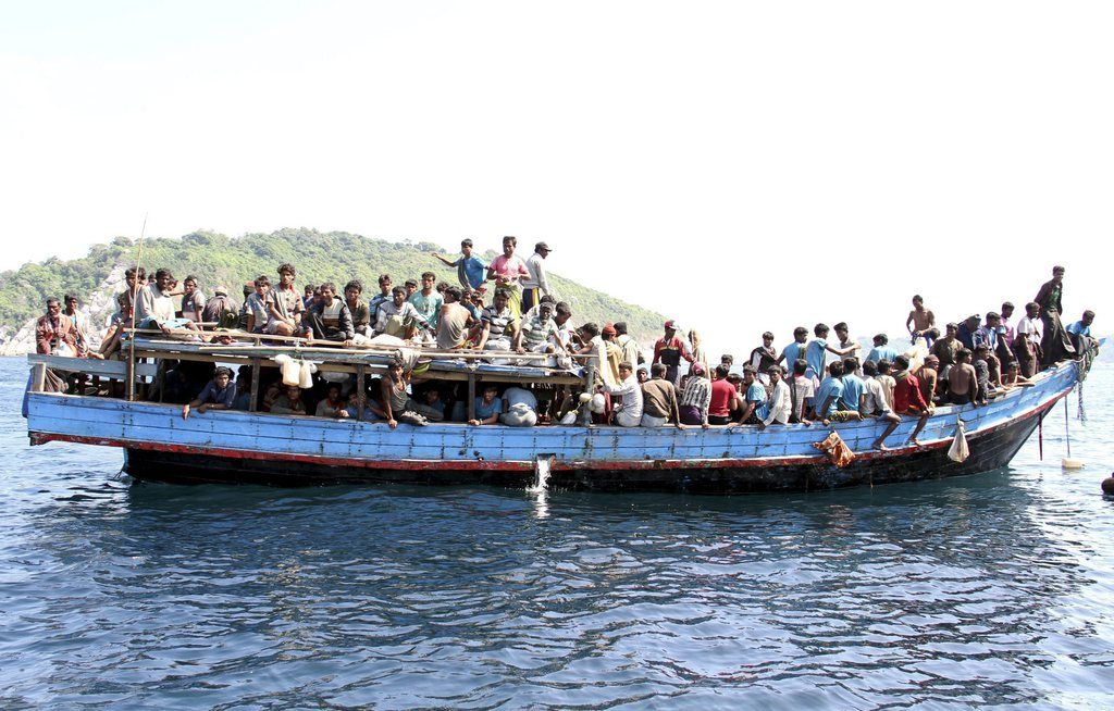 epa03560484 Ethnic Rohingya refugees from Myanmar gather on a boat as they are being rescued by Thai Navy officers before they head to Malaysia, at the Andaman coast, Phuket island, southern Thailand, 29 January 2013. Some 205 of persecuted Rohingya Muslim minority people arrived on a boat in southern Thailand sea coast, on a stopover ahead of their Malaysia destination, where they could seek employment. The Rohingyas, who are not recognized as citizens by Myanmar, were the target of sectarian violence in Rakhine that left more than 100 dead and up to 60,000 displaced.  EPA/YONGYOT PRUKSARAK