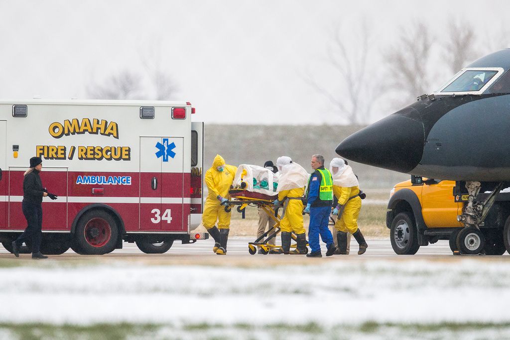 Health workers in protective suits transport Dr. Martin Salia, a surgeon working in Sierra Leone who had been diagnosed with Ebola, from a jet that brought him from Sierra Leone to a waiting ambulance that will take him to the Nebraska Medical Center in Omaha, Neb., Saturday, Nov. 15, 2014. Salia is the third Ebola patient at the Omaha hospital and the 10th person with Ebola to be treated in the U.S. (AP Photo/The World-Herald, Brendan Sullivan) MAGS OUT; ALL NEBRASKA LOCAL BROADCAST TV OUT