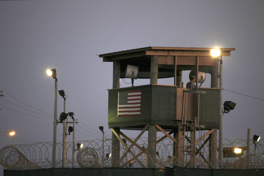 FILE - In this March 29, 2010 photo, reviewed by the U.S. military, a Guantanamo guard keeps watch from a tower overlooking the detention facility at Guantanamo Bay U.S. Naval Base, Cuba. The transfer of prisoners out of Guantanamo Bay has ground to a halt amid a slow Pentagon approval process. That?s caused frustration within the administration and raised doubts that President Barack Obama can fulfill his campaign promise to close the U.S. prison Cuba for terrorism suspects. (AP Photo/Brennan Linsley, File)