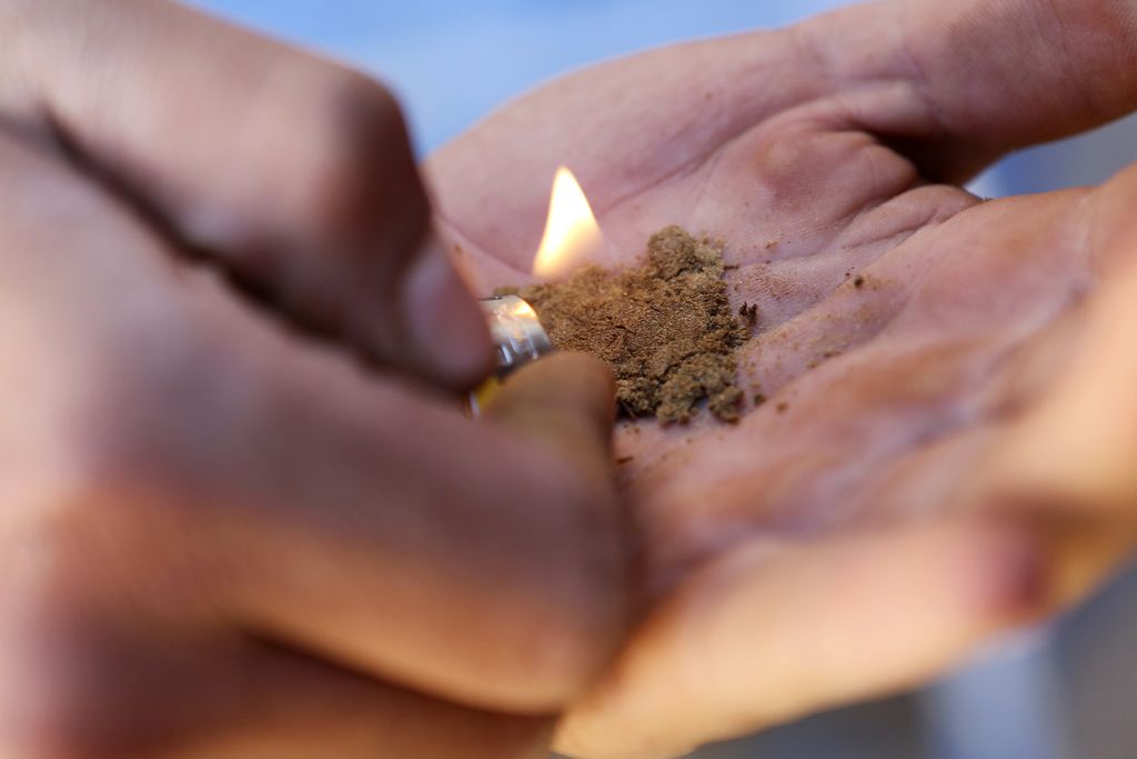 In this Sept. 14, 2014 photo, a worker inspect the crystalline resin powder "extracted hash" by fire in his hand in the Village of Bni Ahmed in the Ketama Abdelghaya valley, northern Morocco. There are an estimated 80,000 families in the rugged northern Rif mountains of Morocco who make their living from growing marijuana, according to U.N. estimates and their efforts have made Morocco the main hashish supplier for Europe and the world. (AP Photo/Abdeljalil Bounhar)