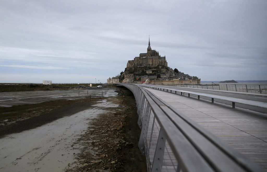 View of the bridge leading to Mont-Saint-Michel designed by Austrian-born architect Dietmar Feichtinger, in Mont Saint Michel, western France, Tuesday, Dec. 9, 2014. The  new bridge leading out from the coastline to the historic Mont Saint-Michel island commune allow the sea to flow across the estuary, transforming the Mont back into a real island for the first time in over a century. (AP Photo/Christophe Ena)