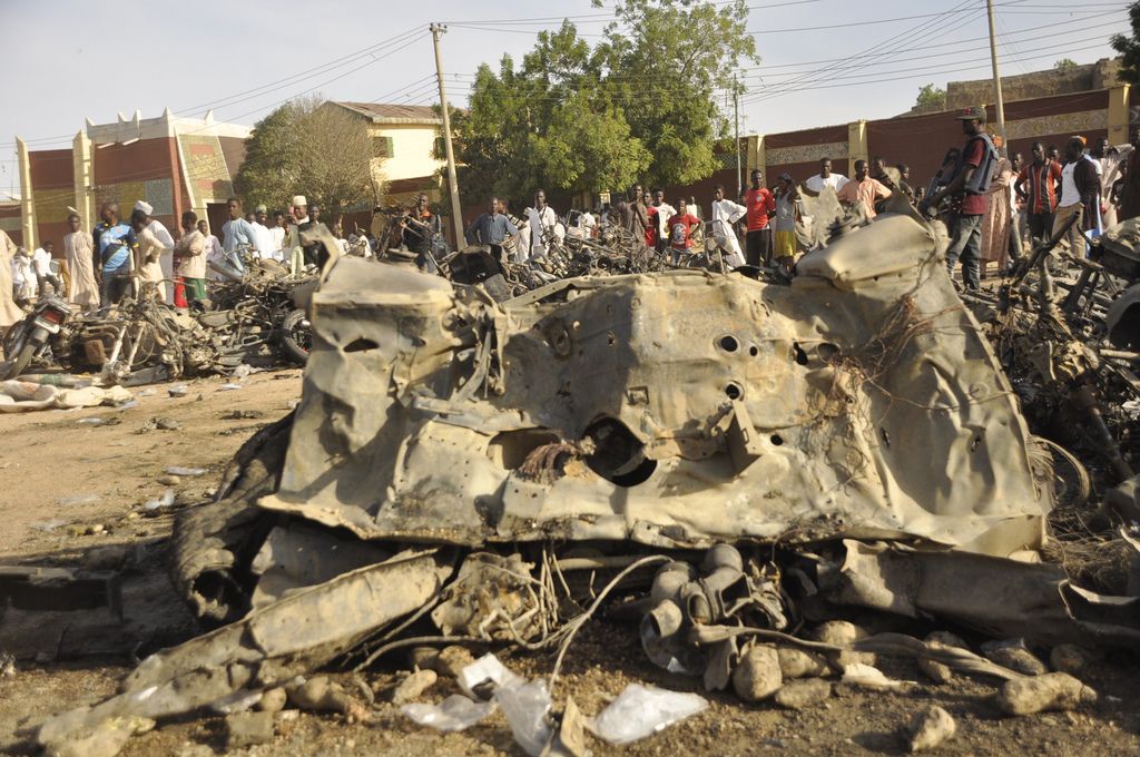 People gather at the site of a bomb explosion in Kano, Nigeria, Friday Nov. 28, 2014. An explosion tore through the central mosque in Nigeria's second-largest city on Friday, and officials feared the casualty toll would be high. Capt. Ikechukwu Eze said the Friday blast occurred at the main mosque in the city of Kano. Hundreds had gathered to listen to a sermon in a region terrorized by attacks from the militant group Boko Haram. (AP Photo/Muhammed Giginyu)
