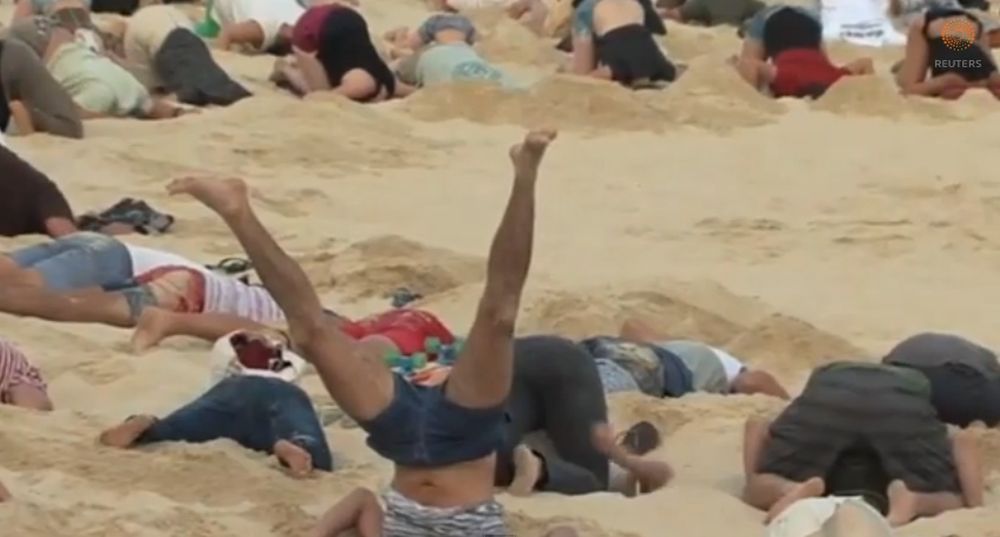Les manifestants ont plongé leur tête dans le sable durant 3 minutes.