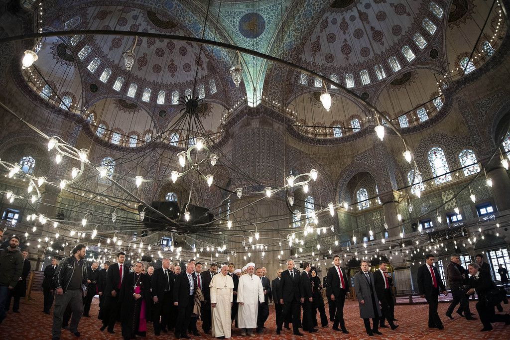 In this photo provided by Vatican newspaper L'Osservatore Romano, Pope Francis and Grand Mufti of Istanbul, Rahmi Yaran visit the Sultan Ahmet mosque in Istanbul, Saturday, Nov. 29, 2014. Meeting with Turkish leaders in the capital Ankara a day earlier, Francis urged Muslim leaders to condemn the "barbaric violence" being committed in Islam's name against religious minorities in Iraq and Syria. (AP Photo/L'Osservatore Romano)