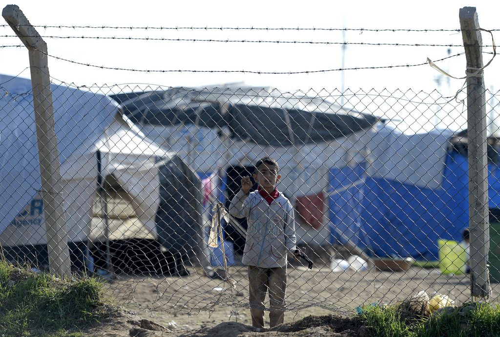 epa04524905 A Yazidi child leans against the perimeter fence of the Baharka refugee camp, near the capital of the Iraqi-Kurdish region Erbil, Iraq, 11 December 2014. According to reports the camp houses over 3,600 people, some of the estimated 1.5 million people of various ethnic and religious groups forced to flee their homes as fighters from the group calling themselves the Islamic State (IS) took control, many finding shelter in the predominantly Kurdish north of Iraq.  EPA/DAREK DELMANOWICZ POLAND OUT