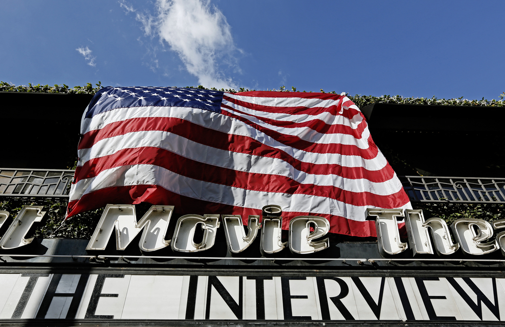"The Interview," the comedy starring Seth Rogen and James Franco, is listed under an American flag on the marquee of the  Cinefamily at Silent Movie Theater in Los Angeles on Thursday, Dec. 25, 2014. The film's Christmas Day release was canceled by Sony after threats of violence by hackers linked to North Korea, but the release was reinstated in some independent theaters and through a variety of digital platforms. (AP Photo/Richard Vogel)