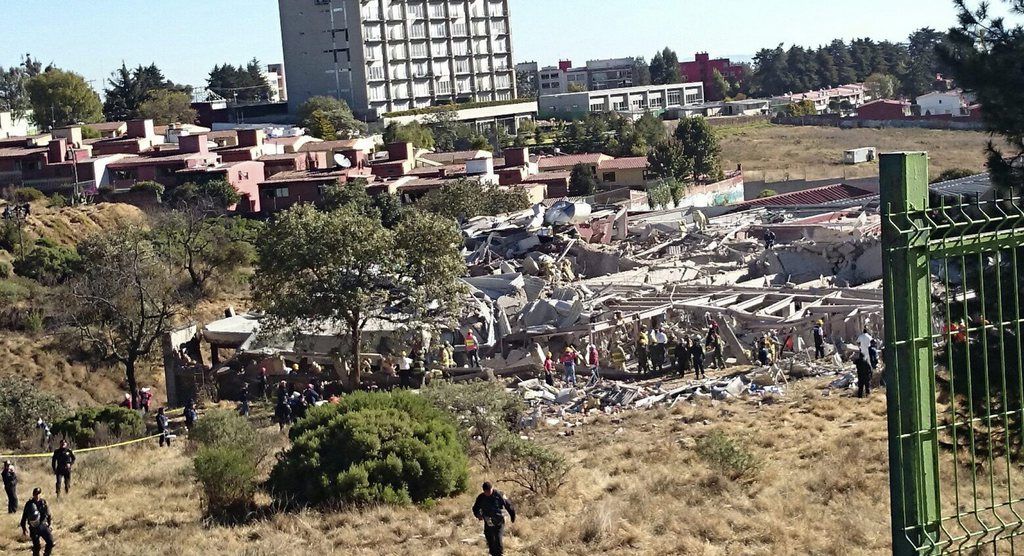 epa04593664 Members of the Mexican Civil protection, police and firefighters during the rescue operation at the Children's Hospital where a gas tanker exploded when it was supplying the public hospital in Mexico City, Mexico, 29 January 2015. A gas truck exploded at a children's hospital in Mexico City, killing at least seven people and injuring at least 32, Mayor Miguel Angel Mancera says. Some 54 people, including 22 children, have been evacuated.  EPA/JORGE NUNEZ