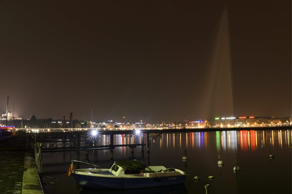 The Geneva harbour with its famous water fountaine (Jet d'eau) in center, and the cathedral St. Pierre (L) with lights switched off during 'Earth Hour', in Geneva, Switzerland, 23 March 2013 evening. 'Earth Hour' is a campaign to encourage businesses, communities and individuals to take the simple steps needed to cut their emissions. The event is the seventh annual 60 minutes of self-imposed darkness intended to highlight the need to cut greenhouse gases behind global warming. (KEYSTONE/Laurent Gillieron)