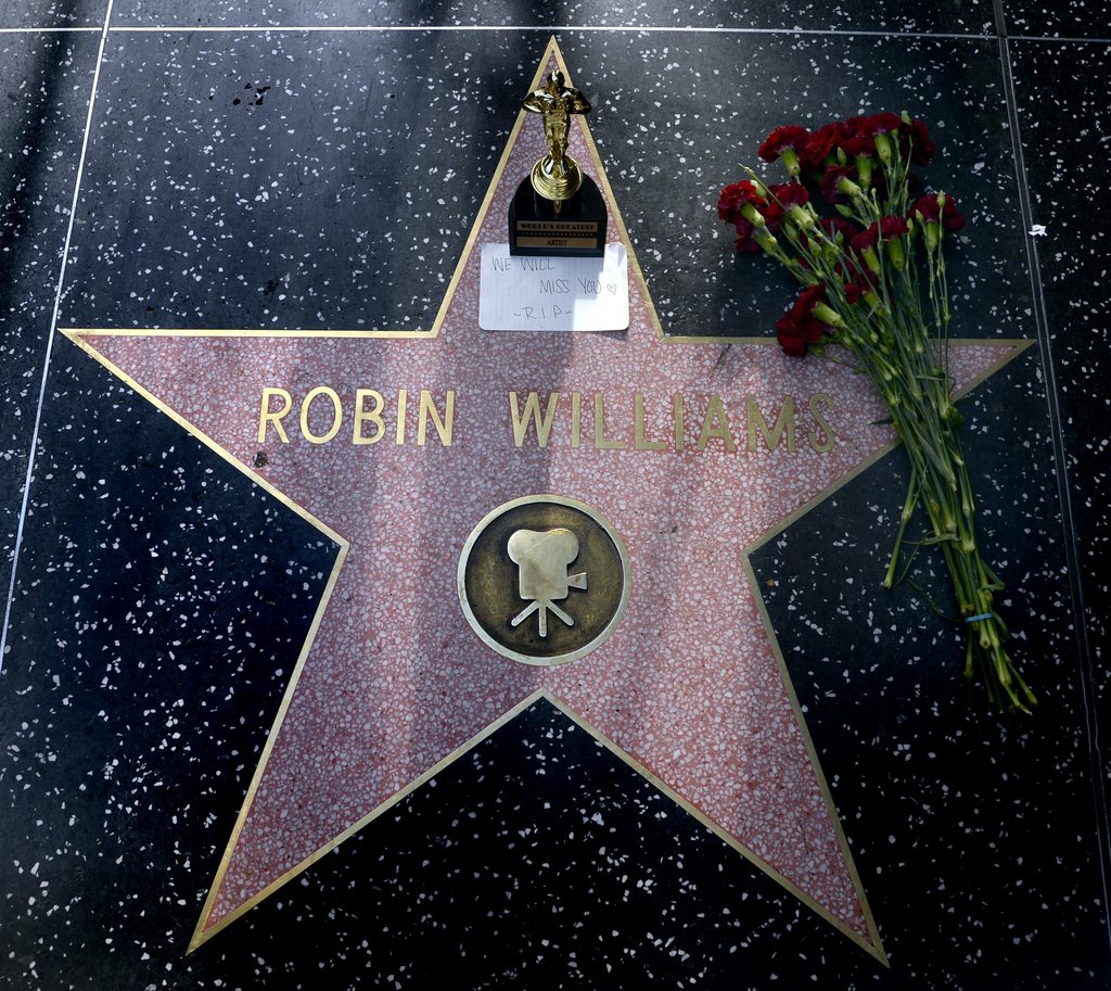 epa04349919 Flowers and an Oscar souvenir are placed on the Hollywood Walk of Fame star for US actor Robin Williams in Hollywood, California, USA, 11 August 2014. The Oscar winning actor Williams who starred in such films as Mrs. Doubtfire and Good Morning Vietnam died of an apparent suicide in his Tiberon home north of San Francisco, California, USA, 11 August 2014.  EPA/MICHAEL NELSON