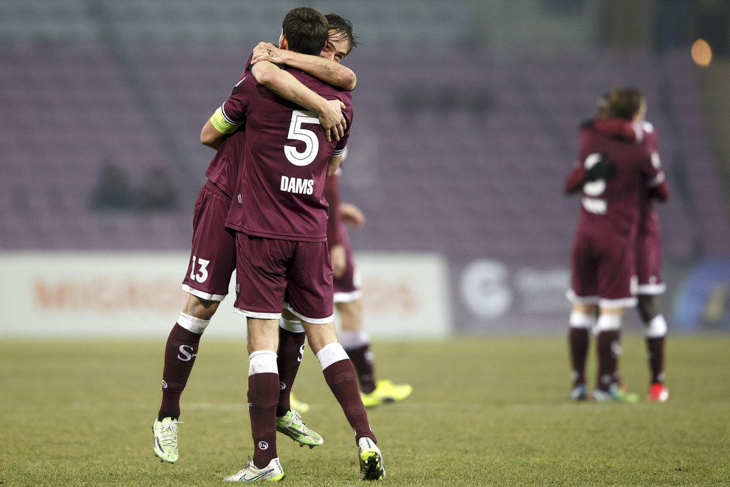Servette's players Bruno Martgnoni and Niklas Dams, nr. 5, celebrate their victory after beating the FC Lugano, at the Challenge League soccer match of Swiss Championship between Servette FC and FC Lugano, at the Stade de Geneve stadium, in Geneva, Switzerland, Monday, February 16, 2015. (KEYSTONE/Salvatore Di Nolfi)